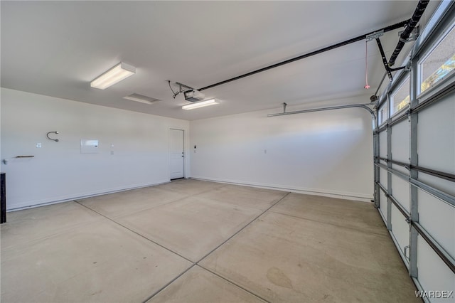 garage with baseboards and a garage door opener