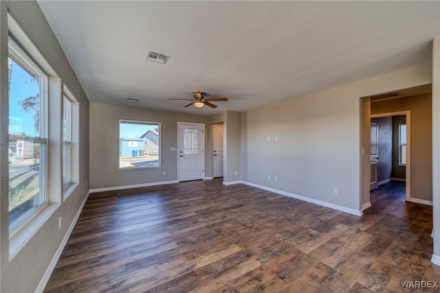 interior space featuring dark wood-type flooring, visible vents, baseboards, and a ceiling fan