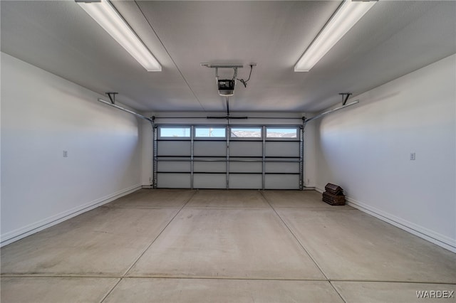 garage with baseboards and a garage door opener