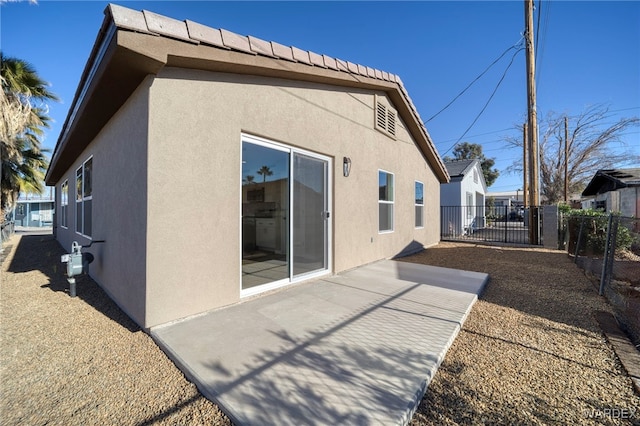 rear view of house with fence and stucco siding