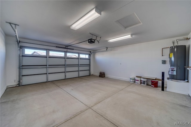 garage with baseboards, a garage door opener, and electric water heater