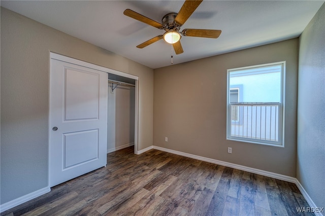 unfurnished bedroom featuring a closet, baseboards, and dark wood-type flooring