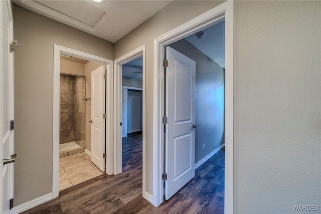 corridor featuring dark wood-style floors and baseboards