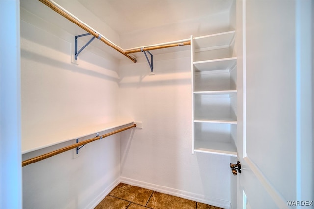 walk in closet with dark tile patterned flooring