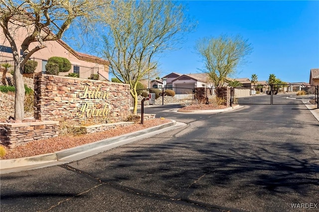 view of road with curbs, a gated entry, a gate, and a residential view