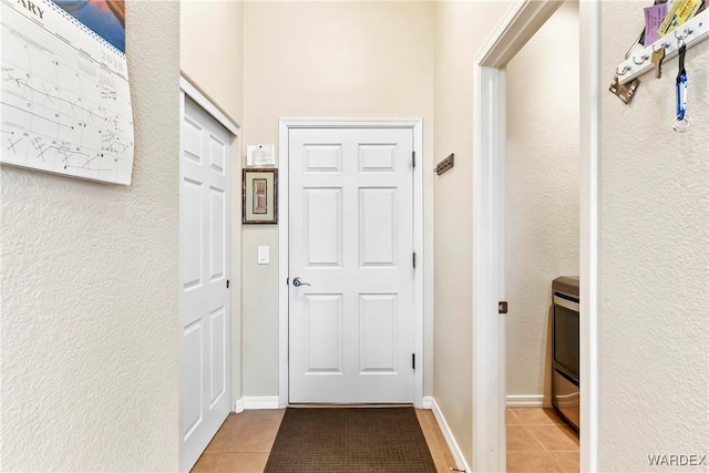 entryway with light tile patterned floors and baseboards