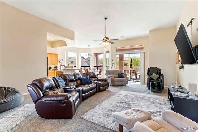 living area with carpet floors, baseboards, and a ceiling fan