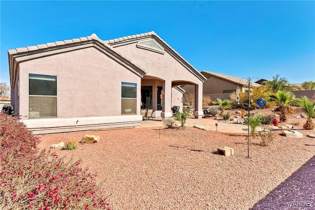 back of property featuring a patio area and stucco siding