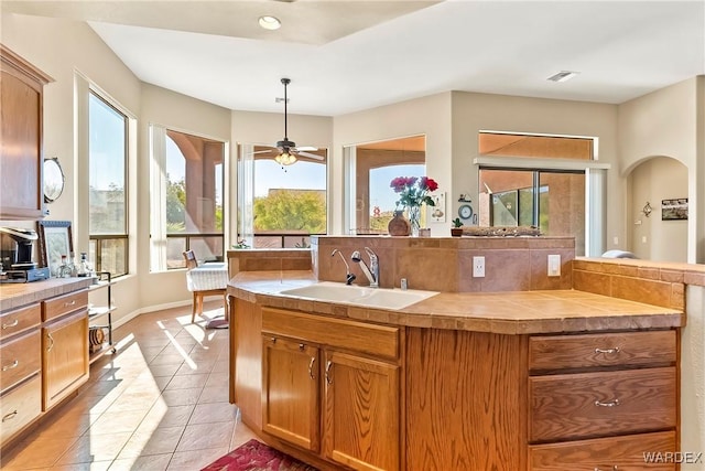 kitchen featuring a healthy amount of sunlight, light countertops, a sink, and decorative light fixtures