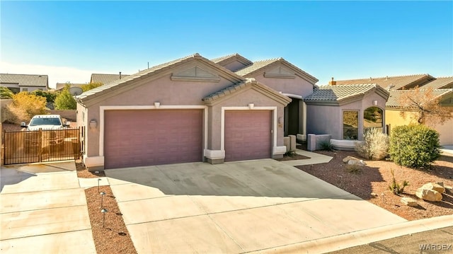 view of front of home with a garage, a tiled roof, concrete driveway, and stucco siding