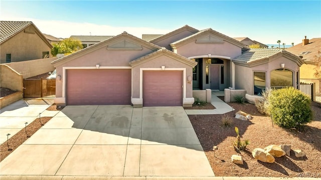 view of front of house featuring a garage, driveway, a tile roof, fence, and stucco siding