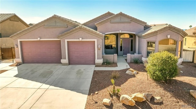 view of front of house featuring concrete driveway, an attached garage, a tile roof, and stucco siding