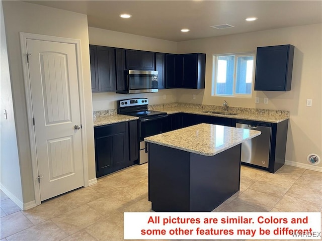 kitchen featuring light stone counters, recessed lighting, appliances with stainless steel finishes, a sink, and a kitchen island