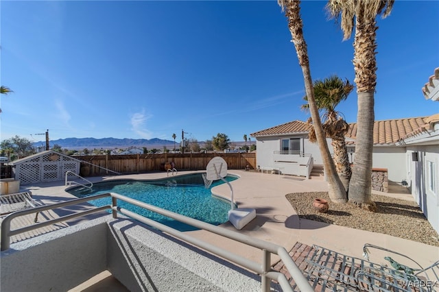 view of pool featuring a patio area, a fenced backyard, a mountain view, and a fenced in pool