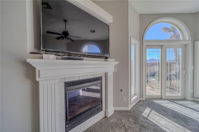 interior details with ceiling fan, a fireplace, visible vents, baseboards, and carpet