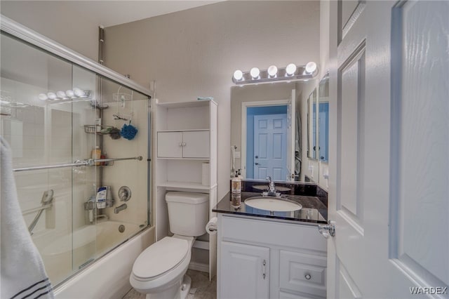 bathroom with shower / bath combination with glass door, vanity, and toilet