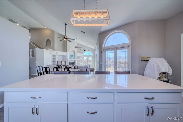 kitchen with open floor plan, light countertops, white cabinetry, and a center island