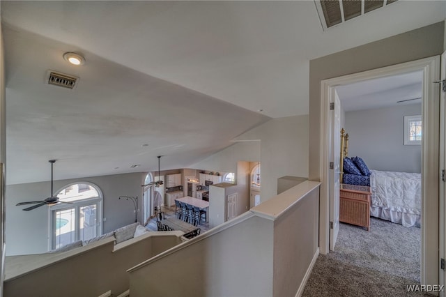 hallway featuring a wealth of natural light, carpet, an upstairs landing, and visible vents