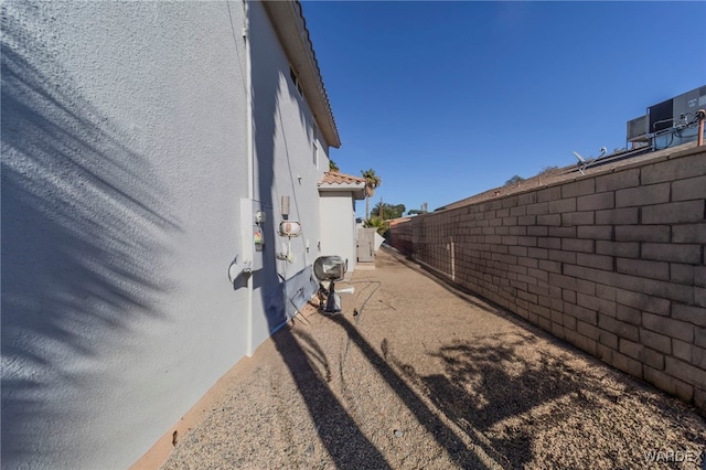 exterior space featuring a tile roof, a fenced backyard, and stucco siding