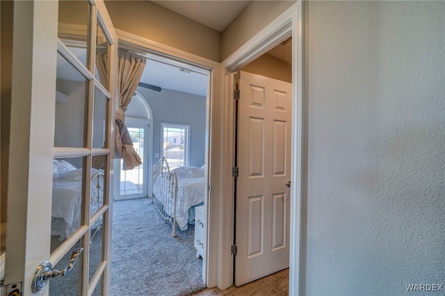 hall featuring a textured wall and carpet flooring