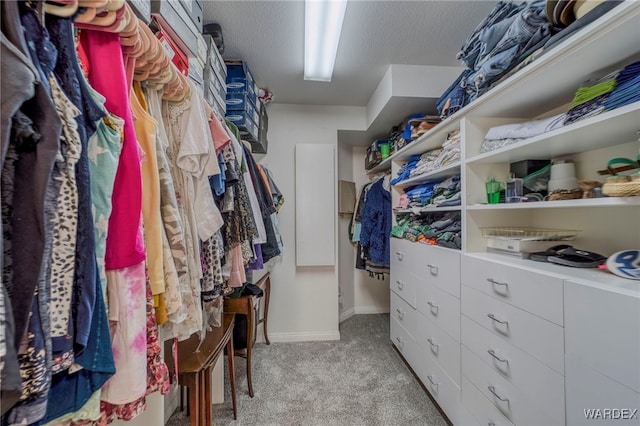 walk in closet featuring light carpet