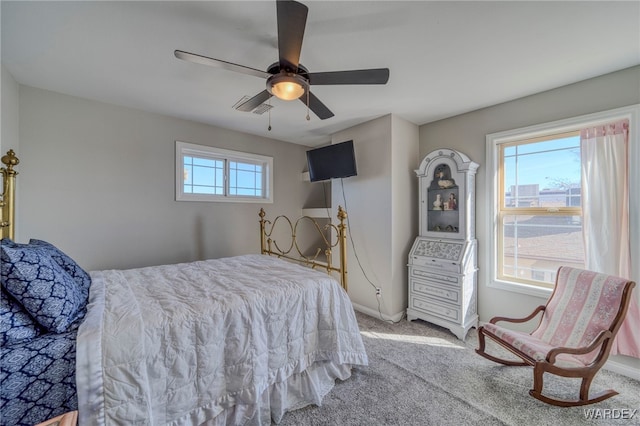 bedroom featuring light carpet, ceiling fan, baseboards, and multiple windows