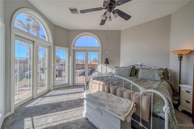 carpeted bedroom featuring access to outside, visible vents, and a ceiling fan