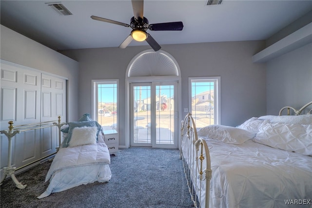 carpeted bedroom featuring access to outside, visible vents, ceiling fan, and multiple windows