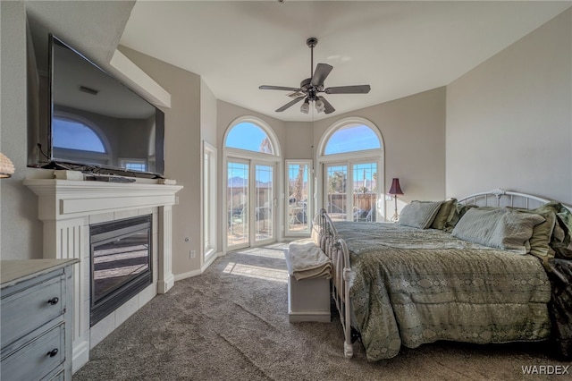 bedroom featuring baseboards, a ceiling fan, light colored carpet, access to exterior, and a fireplace