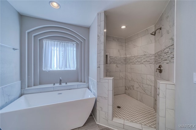 full bathroom with recessed lighting, a soaking tub, and a tile shower