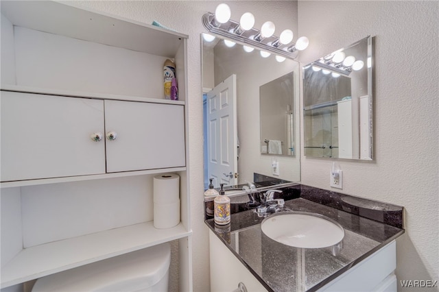 bathroom featuring a textured wall and vanity