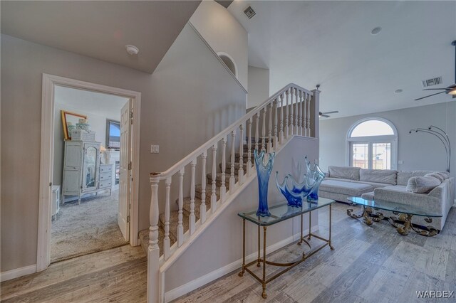 living area featuring ceiling fan, stairway, wood finished floors, and visible vents