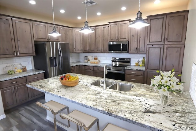 kitchen with stainless steel appliances, visible vents, and dark brown cabinetry