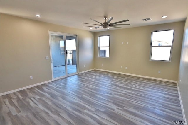 unfurnished room featuring baseboards, visible vents, dark wood-style flooring, and recessed lighting