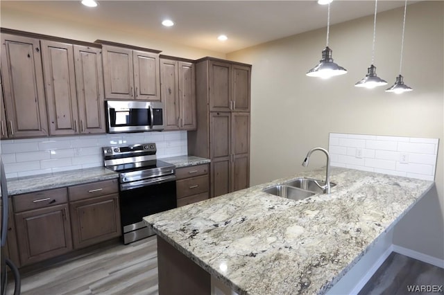 kitchen featuring appliances with stainless steel finishes, a sink, and dark brown cabinets