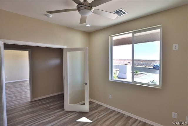 unfurnished bedroom featuring visible vents, ceiling fan, baseboards, and wood finished floors