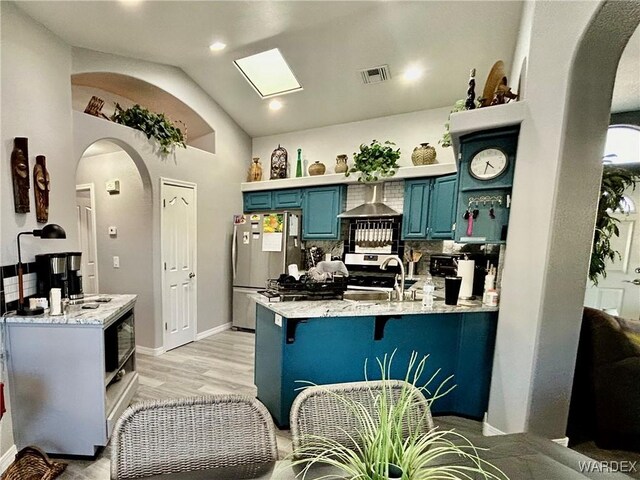 kitchen featuring visible vents, arched walkways, appliances with stainless steel finishes, blue cabinetry, and a sink