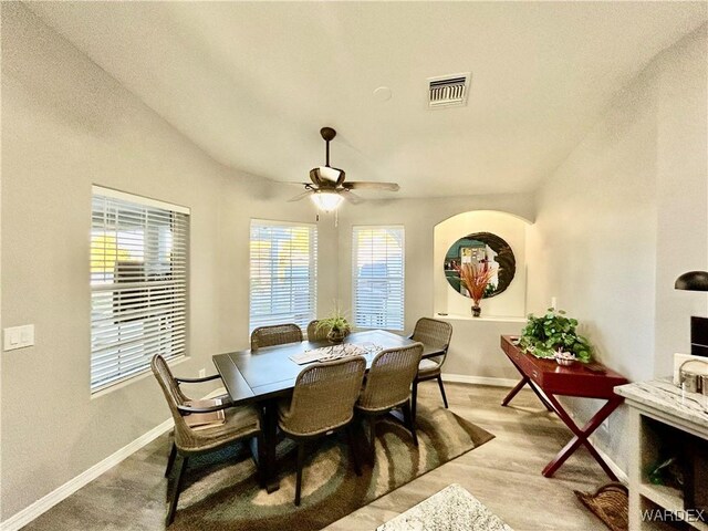 dining room featuring baseboards, visible vents, vaulted ceiling, and a ceiling fan