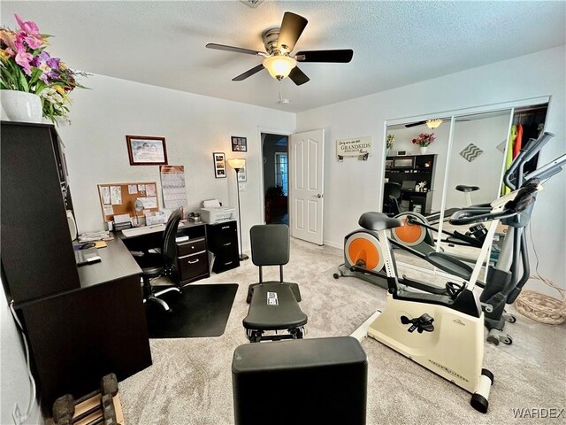 office area featuring a ceiling fan, a textured ceiling, and light colored carpet