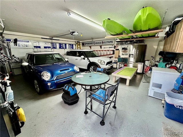 garage with a garage door opener and stainless steel refrigerator with ice dispenser