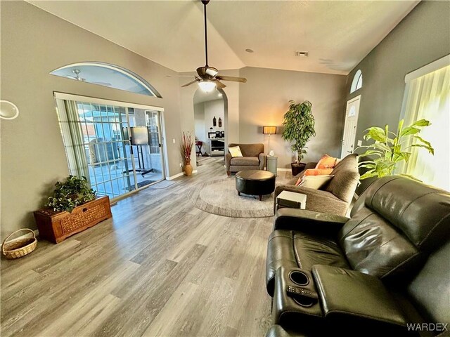 interior space with lofted ceiling, visible vents, light wood-style flooring, ceiling fan, and baseboards