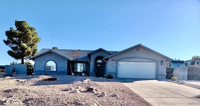 ranch-style house featuring an attached garage, concrete driveway, and stucco siding