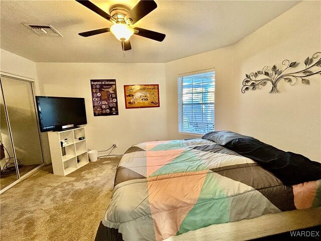 bedroom featuring a ceiling fan, a closet, visible vents, and carpet flooring