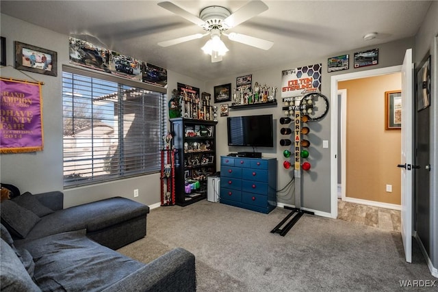 living room with ceiling fan, baseboards, and light colored carpet