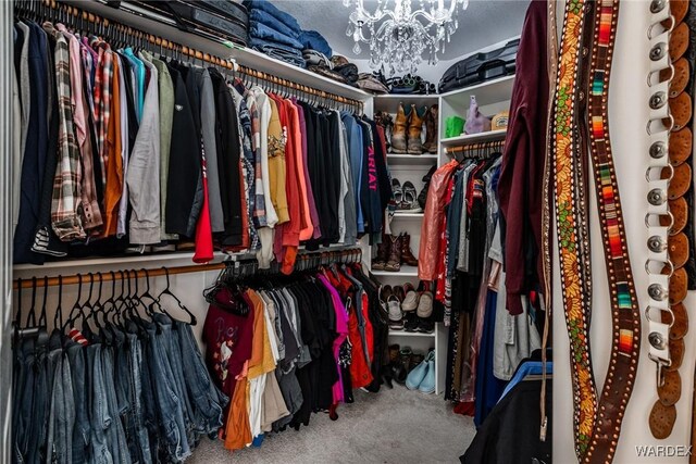 walk in closet featuring carpet and an inviting chandelier