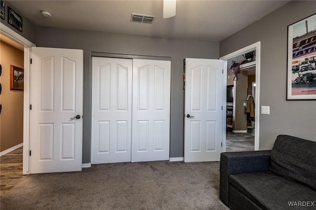 living area with ceiling fan, carpet floors, visible vents, and baseboards