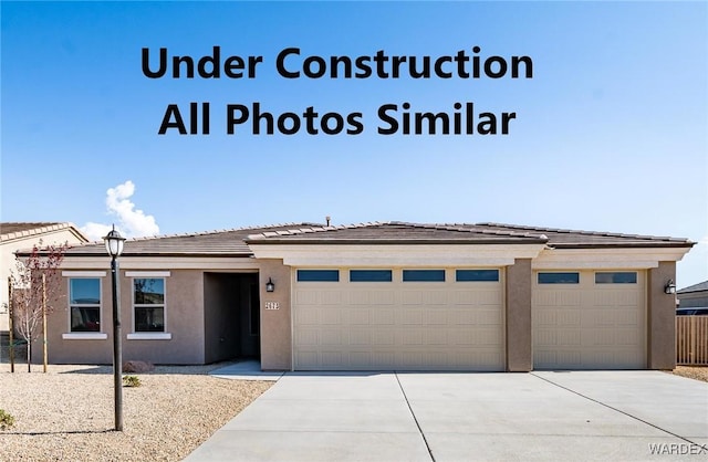 prairie-style home featuring an attached garage, stucco siding, driveway, and a tiled roof