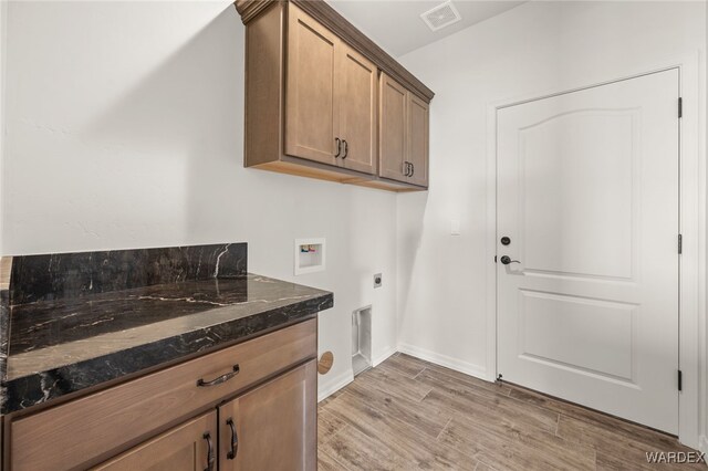 clothes washing area with hookup for a washing machine, visible vents, light wood-type flooring, cabinet space, and electric dryer hookup