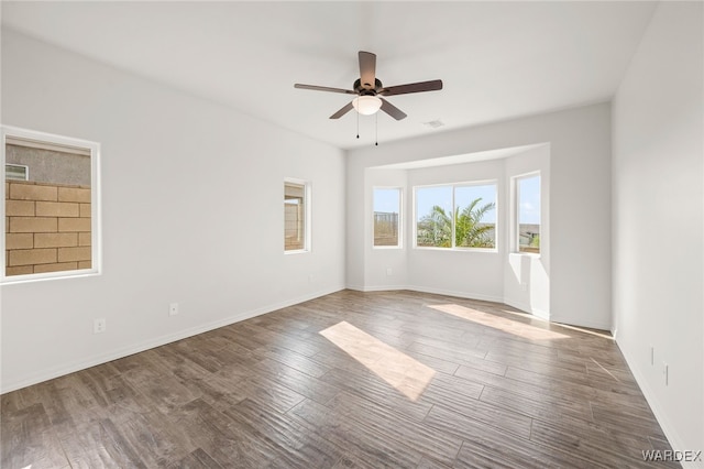 spare room with ceiling fan, baseboards, and wood finished floors