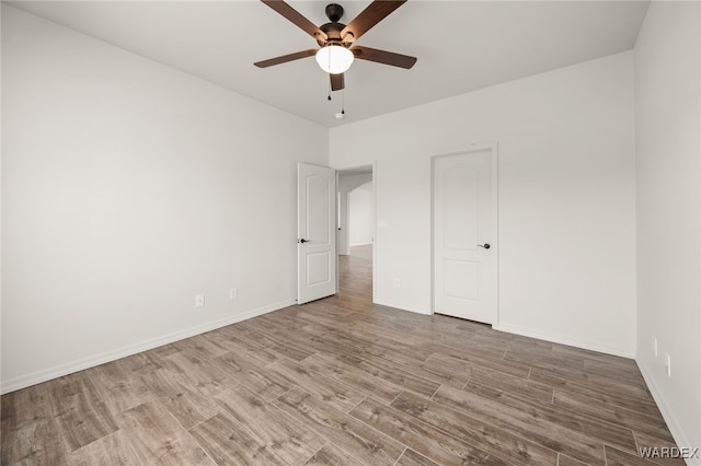 unfurnished bedroom featuring light wood-type flooring, ceiling fan, and baseboards